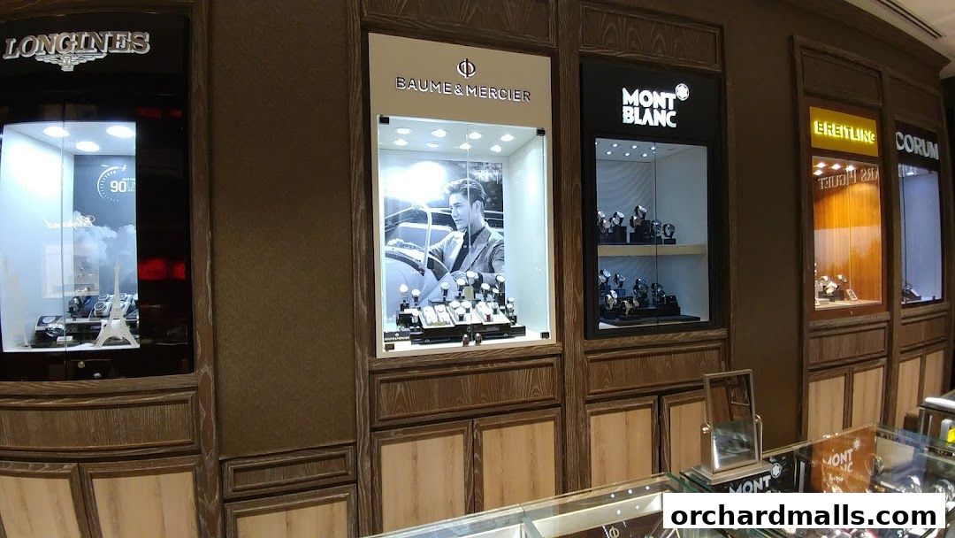 Display windows of a luxury watch store featuring brands like Longines, Baume & Mercier, Mont Blanc, Breitling, and Corum.