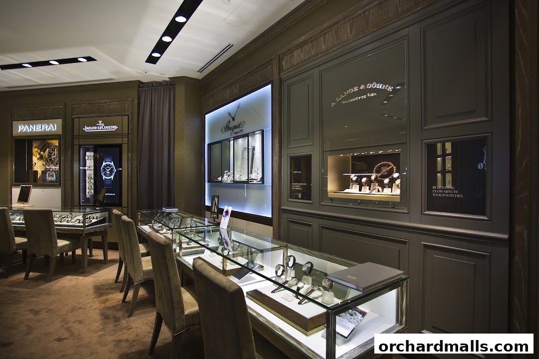 Interior view of a luxury watch store showcasing display cases with watches and brand signage.
