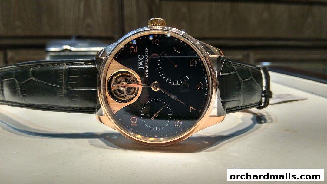A close-up of an IWC Schaffhausen watch with a black alligator strap.