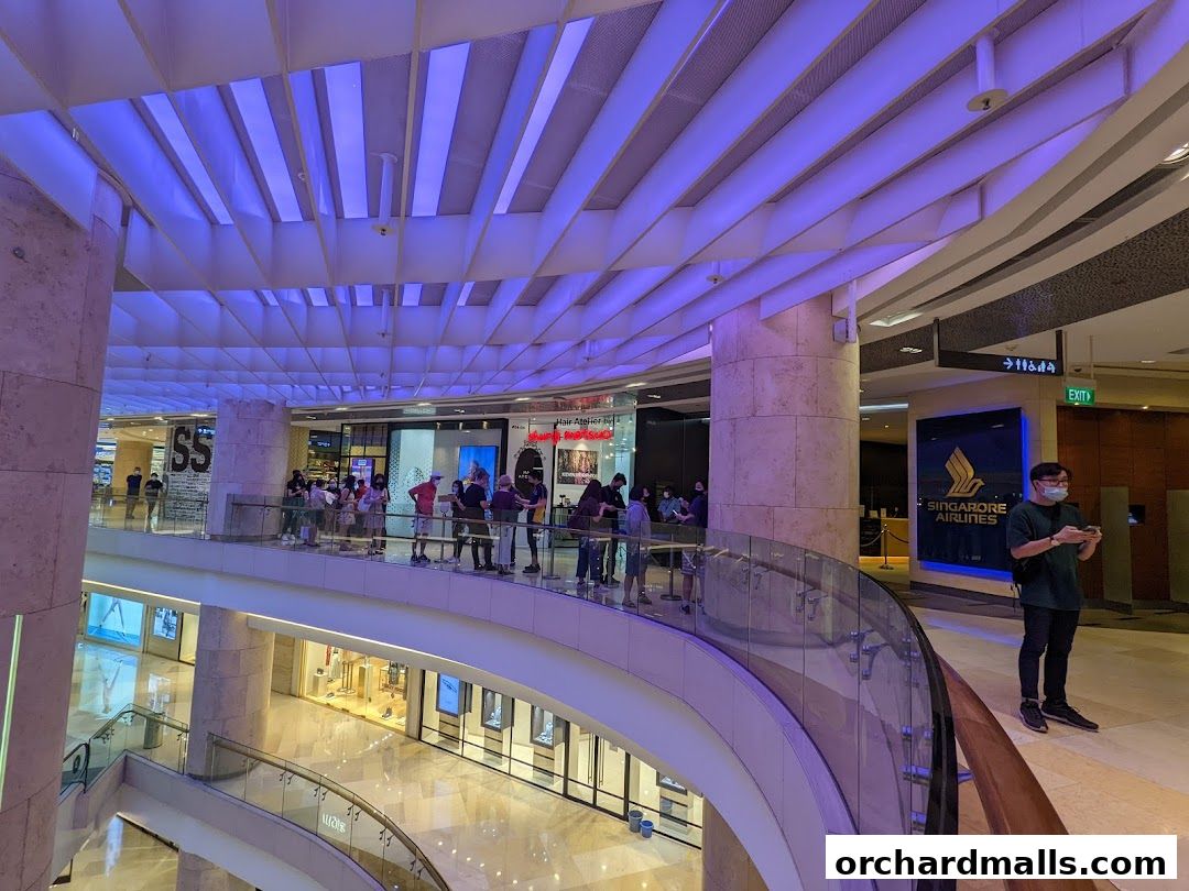 People queuing at the Singapore Airlines Service Centre in a modern shopping mall.