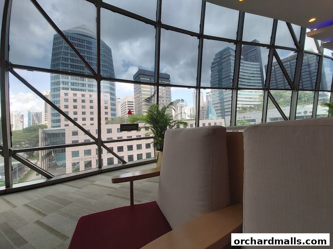 Interior view of a waiting area with comfortable seating and a panoramic view of city skyscrapers.