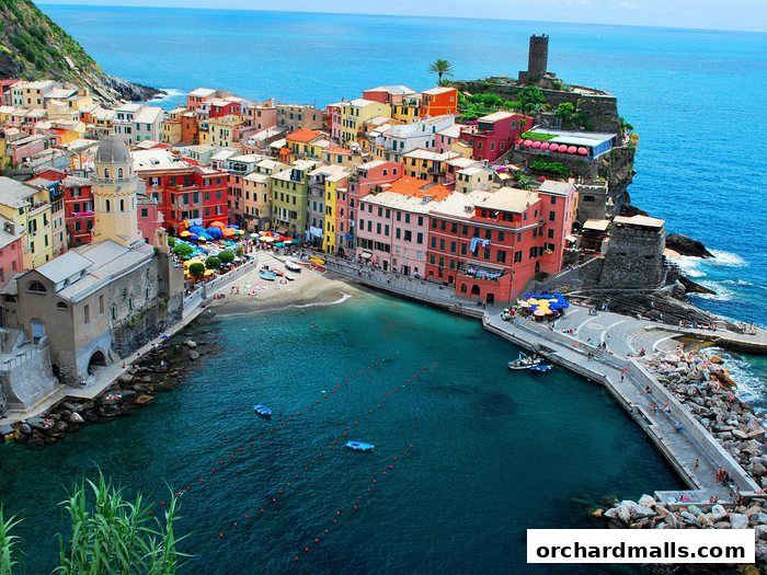 A picturesque coastal village with colorful buildings and a harbor.