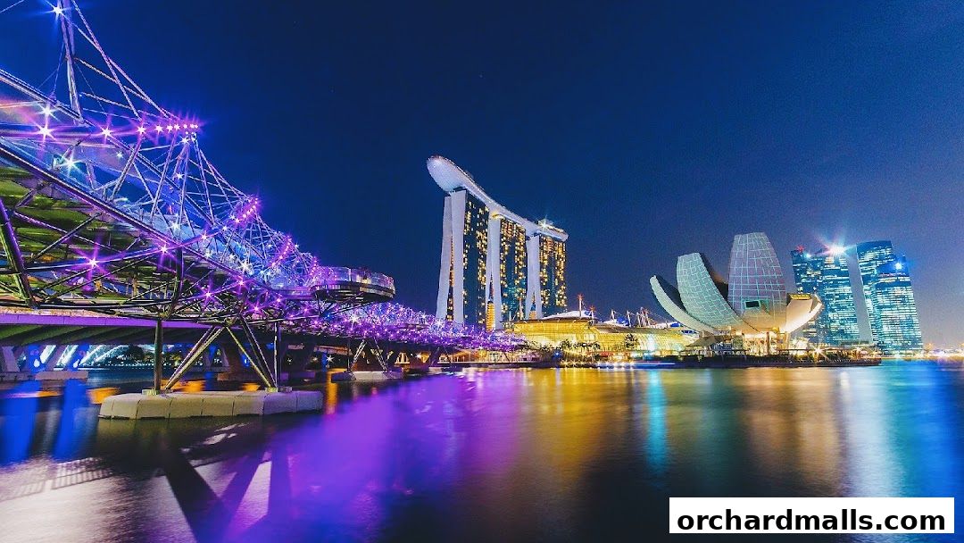 Singapore skyline at night with illuminated Helix Bridge and Marina Bay Sands.