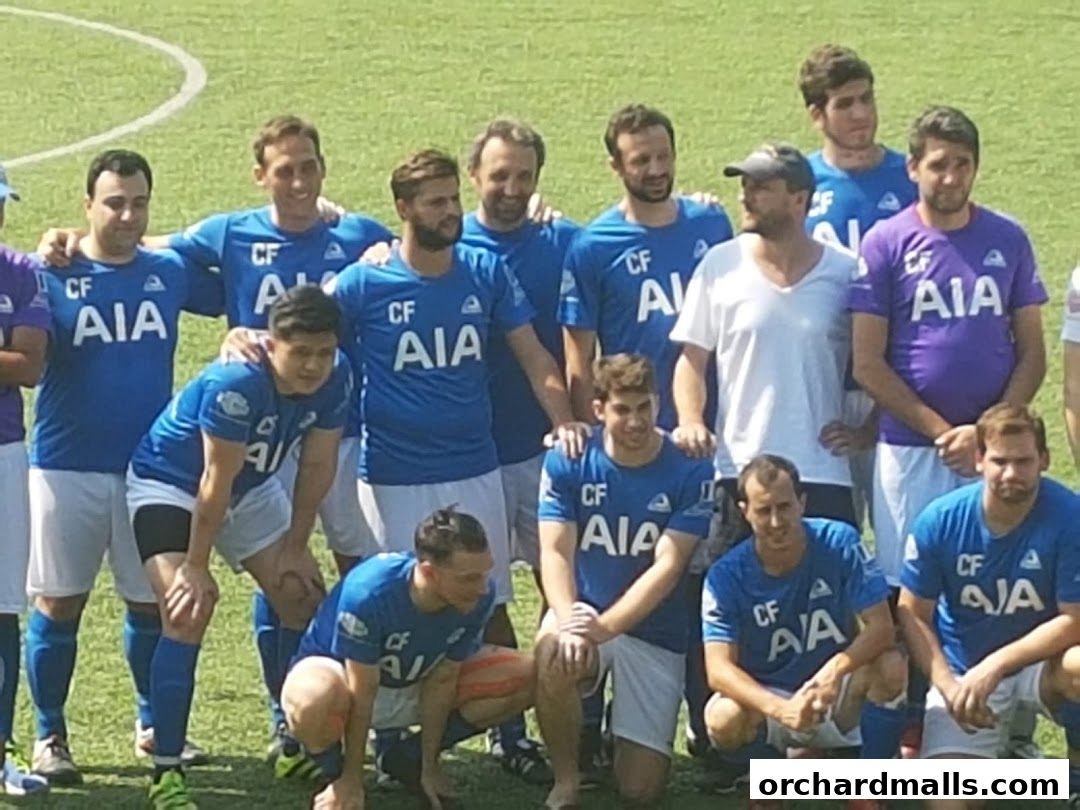 A group of men in soccer uniforms posing for a photo on a grassy field.