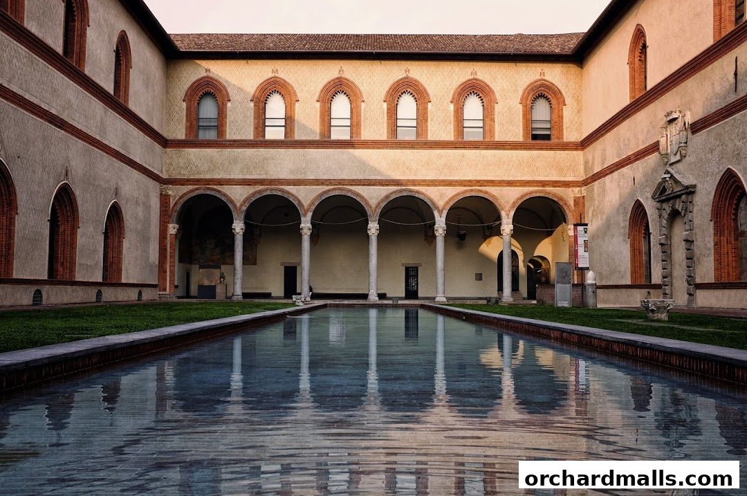 Courtyard with a long reflecting pool and arched colonnades.