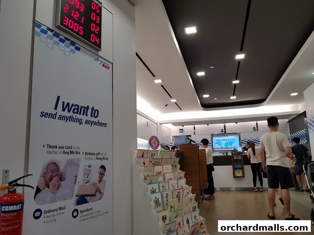 Interior of a Singapore Post branch with customers and a digital queue display.