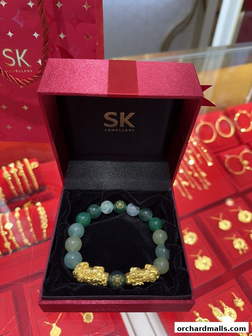 A red gift box displays a jade and gold bracelet with Pixiu charms.