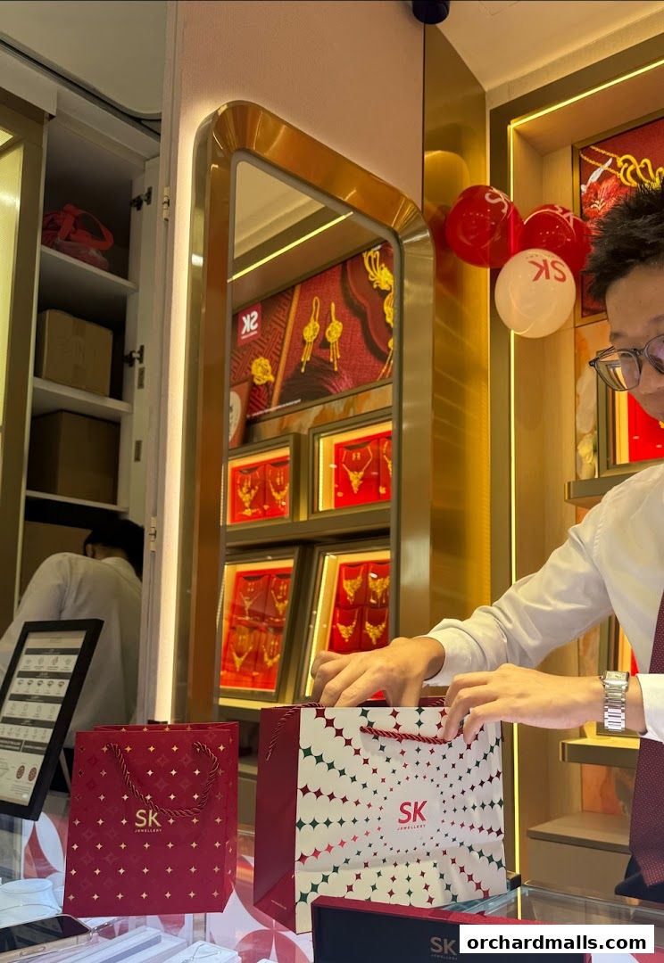 A store employee is packing items into a shopping bag at SK Jewellery.