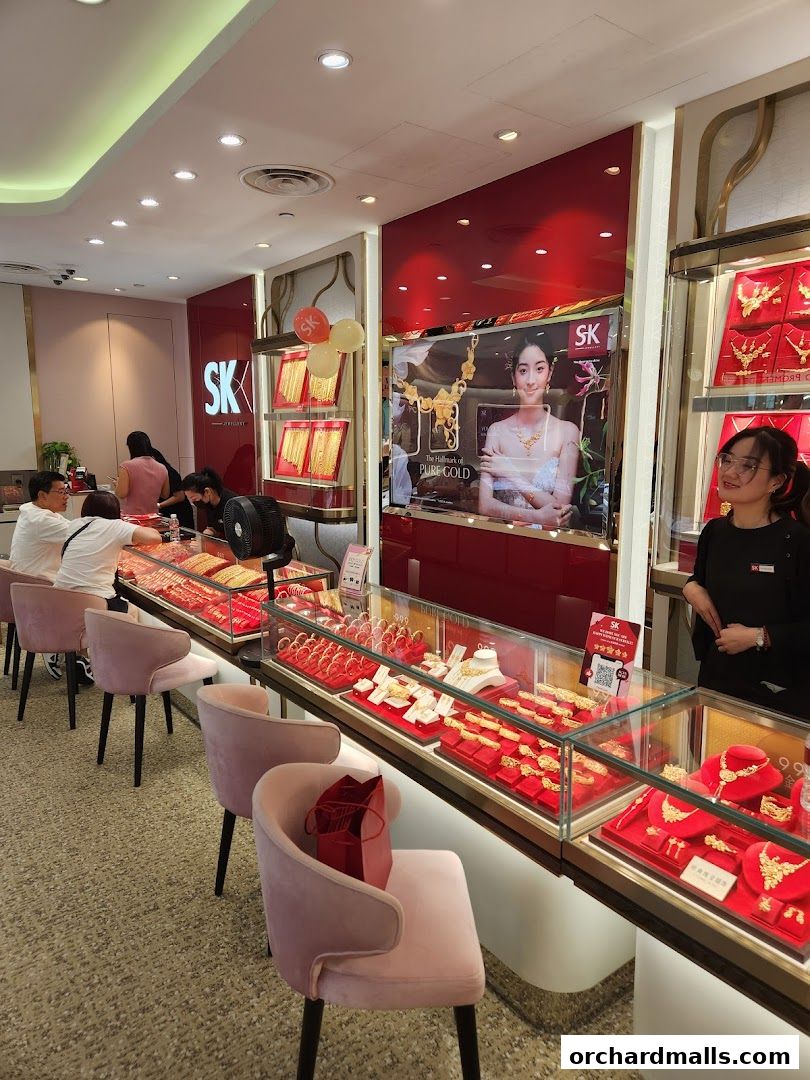 Interior of a jewelry store with displays of gold jewelry and customers being served.
