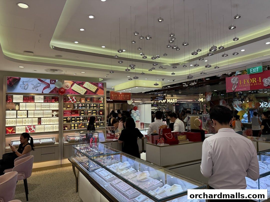 Interior of a SK Jewellery store with displays of gold bars and jewelry, and customers browsing.