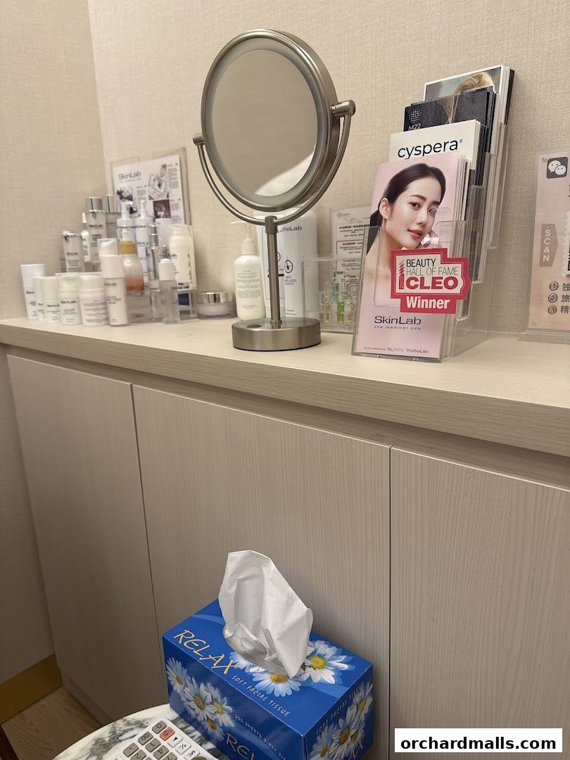 A vanity area with skincare products, a makeup mirror, and promotional materials.