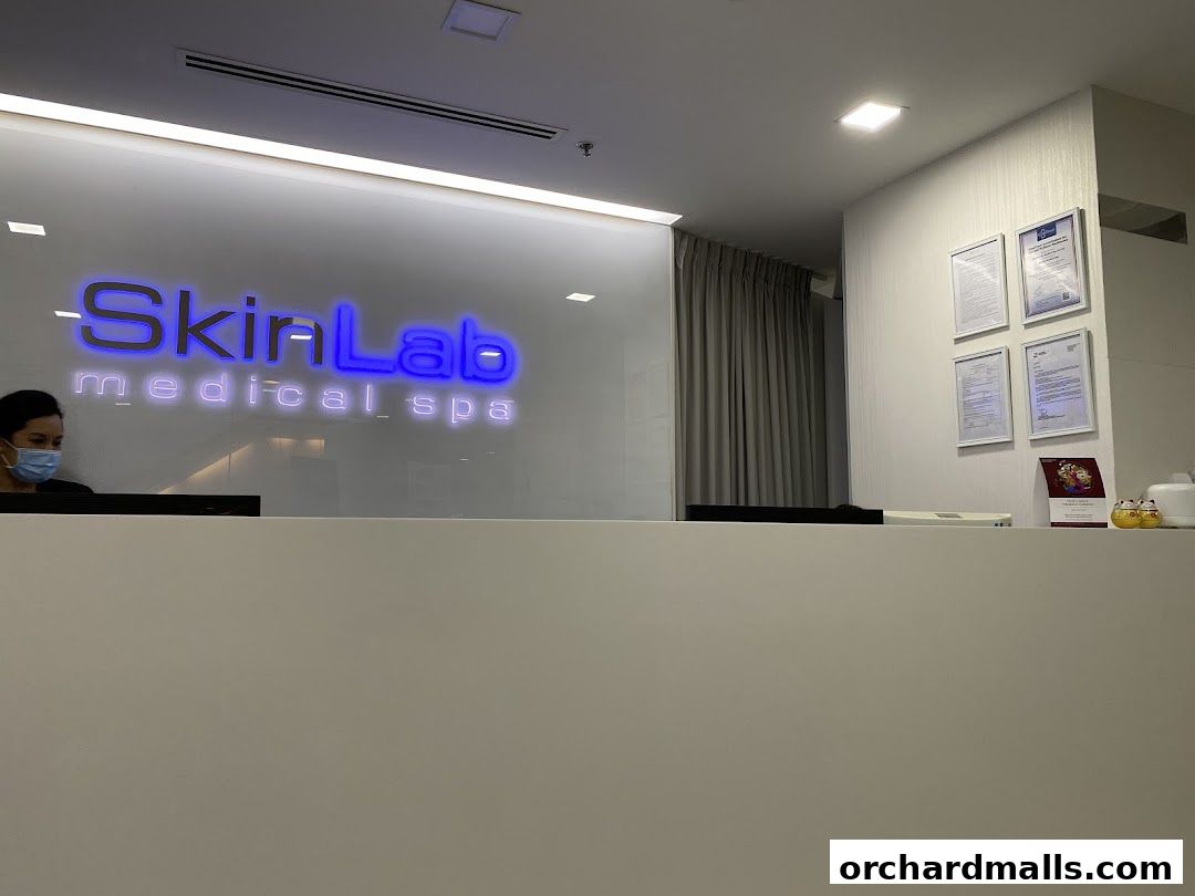 Reception area of SkinLab Medical Spa with a glowing logo and framed certificates.