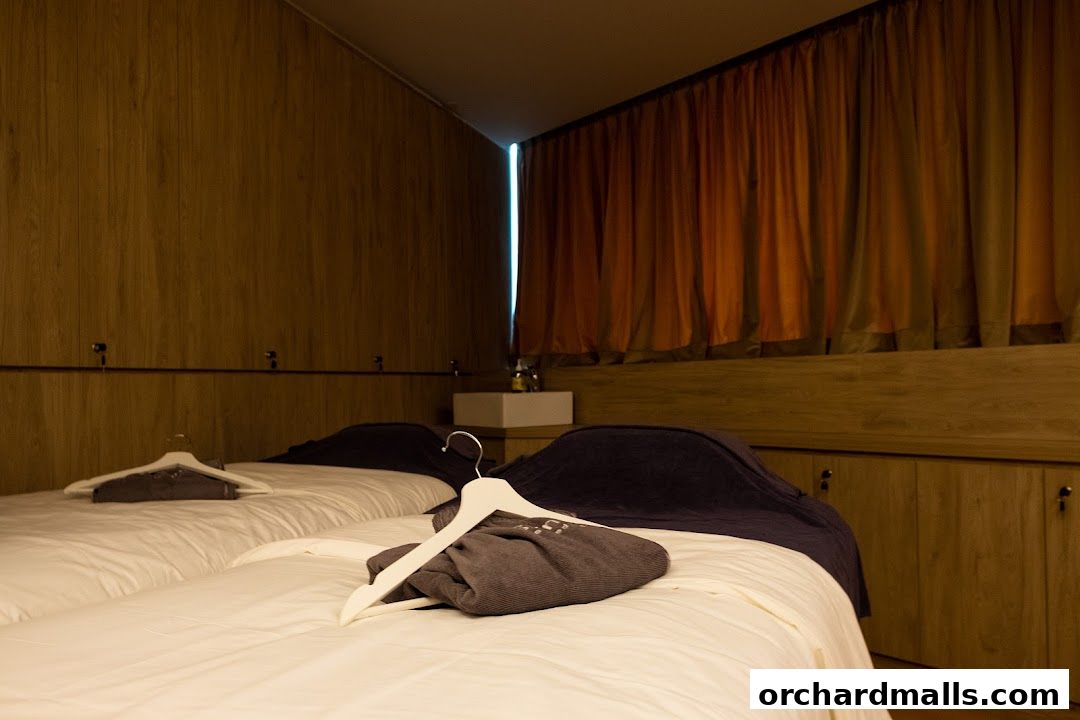 Two massage beds with folded towels and hangers in a spa room.