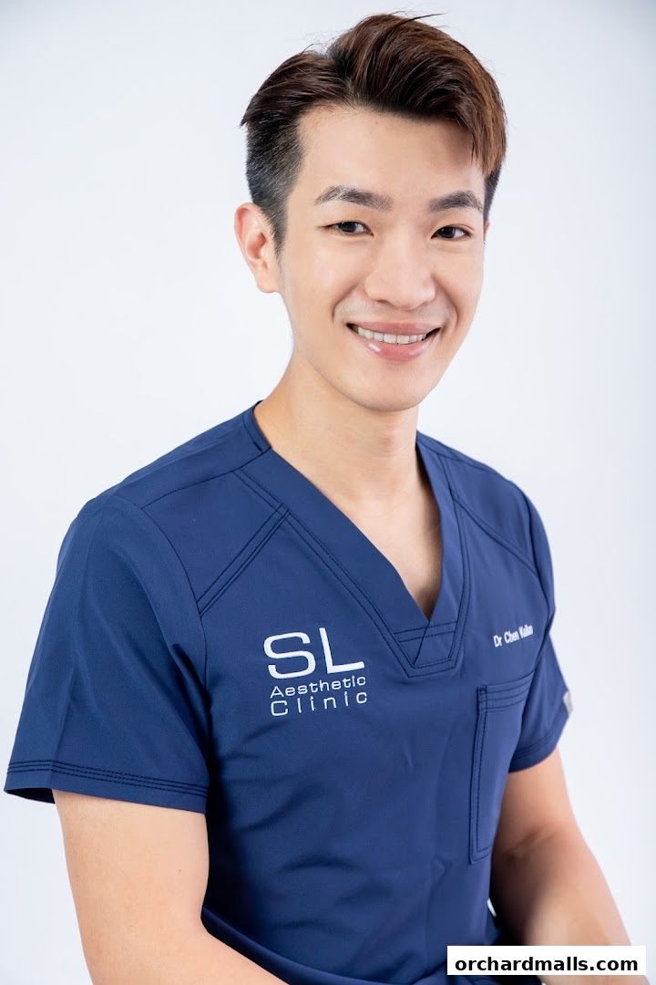 A smiling man in a navy blue scrub top with the SL Aesthetic Clinic logo.