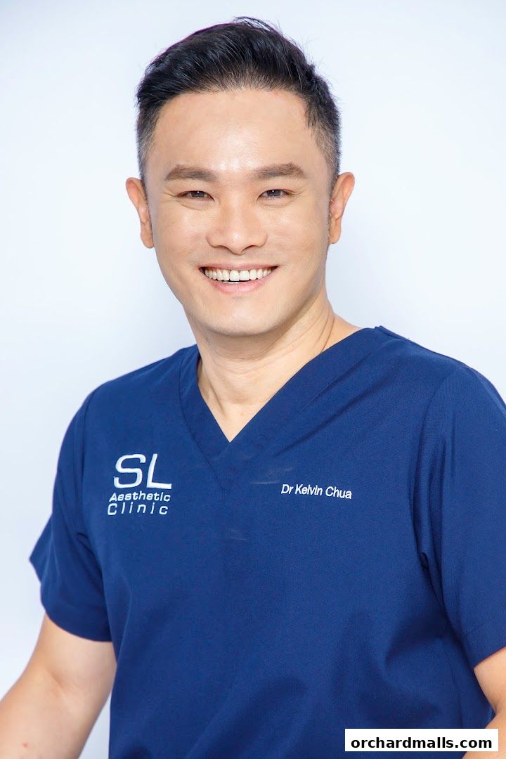 A smiling man in a blue scrub top with the SL Aesthetic Clinic logo.