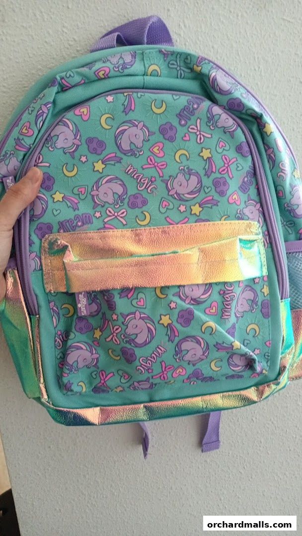 A close-up of a Smiggle backpack with a unicorn and rainbow pattern.