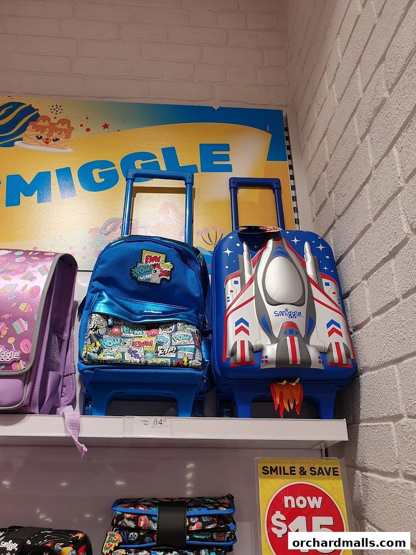 Smiggle shop display featuring colorful backpacks and a trolley bag with a sale sign.