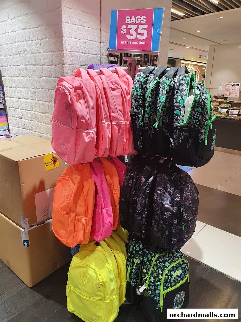 A display of colorful backpacks, including pink, orange, yellow, and patterned designs, with a sign indicating bags are $35.