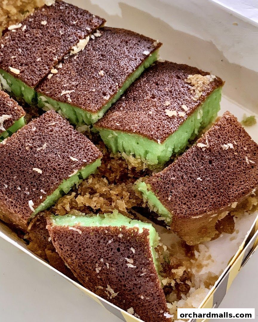 A close-up shot of sliced martabak manis with a green filling and a brown, slightly crispy exterior.