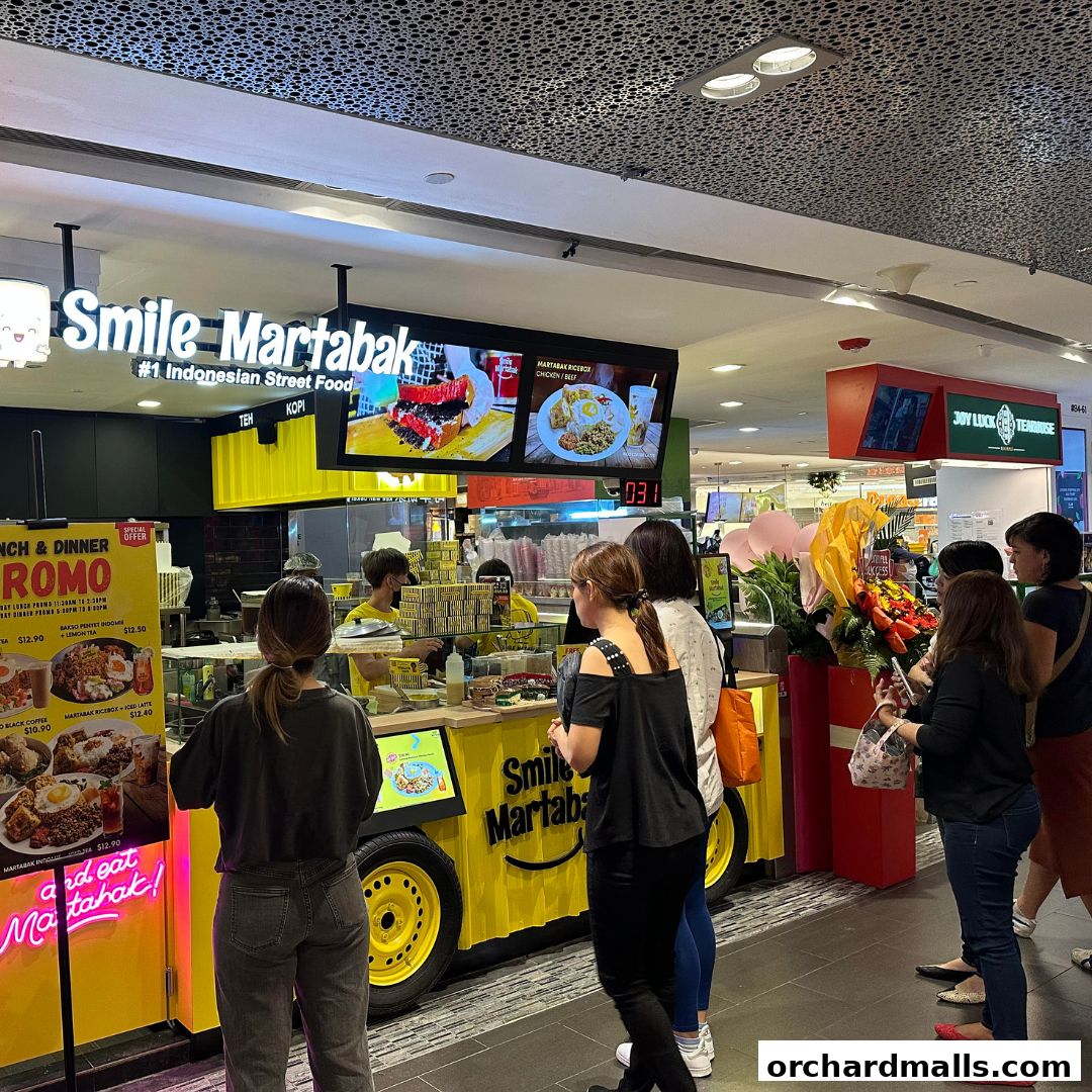 A bright yellow Smile Martabak stall with customers queuing, showcasing Indonesian street food.