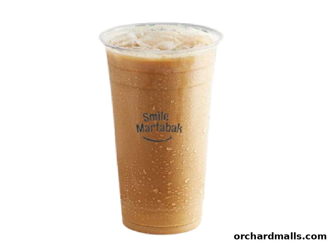 A tall, iced beverage with the Smile Martabak logo on the cup.