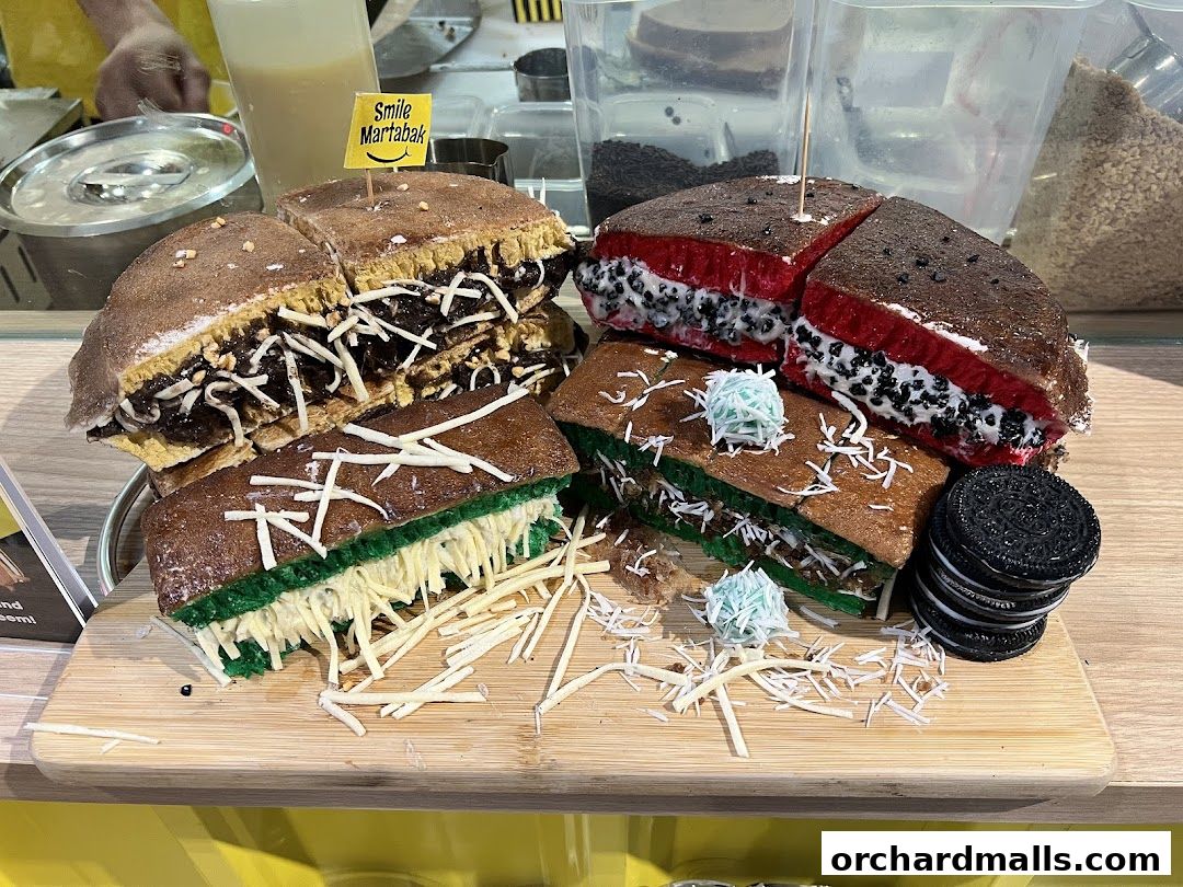 A display of various martabak flavors, including chocolate, cheese, and red velvet with Oreo.