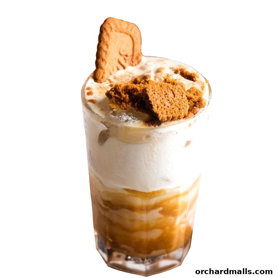 A tall glass filled with a layered dessert, topped with whipped cream and crushed biscuits.