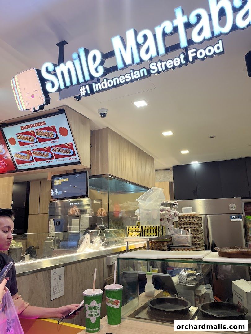 Smile Martabak shop front with a menu display and two green drinks.