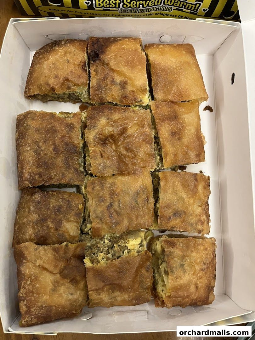 A box of savory martabak, cut into squares, ready to be enjoyed.
