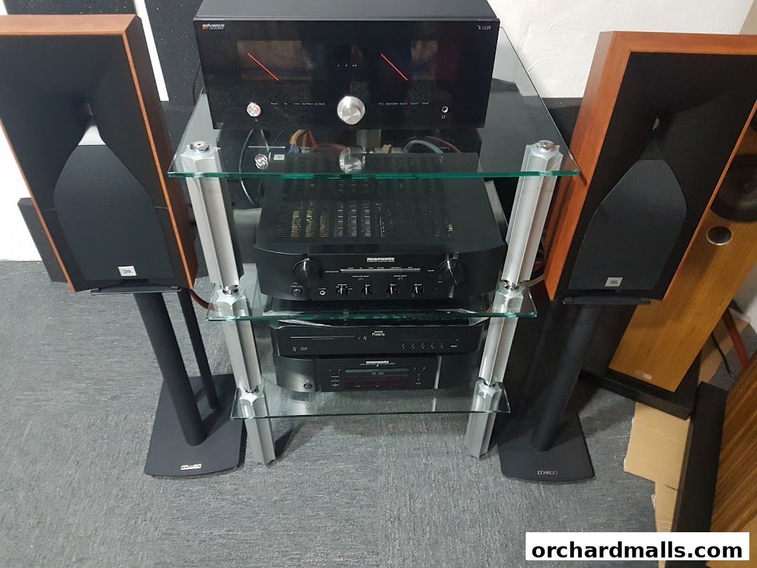 High-fidelity audio equipment including speakers and amplifiers on a glass shelf stand.