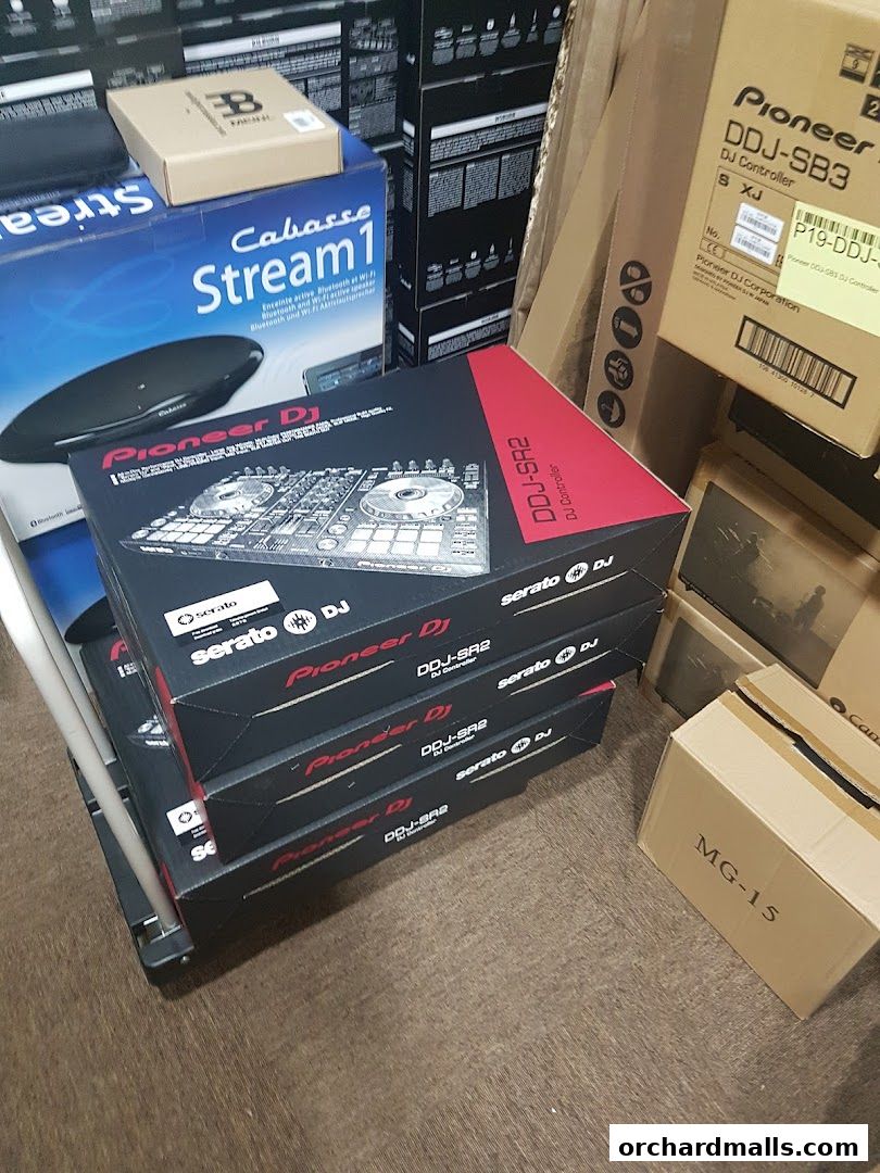 Boxes of Pioneer DJ controllers and other audio equipment stacked in a retail space.