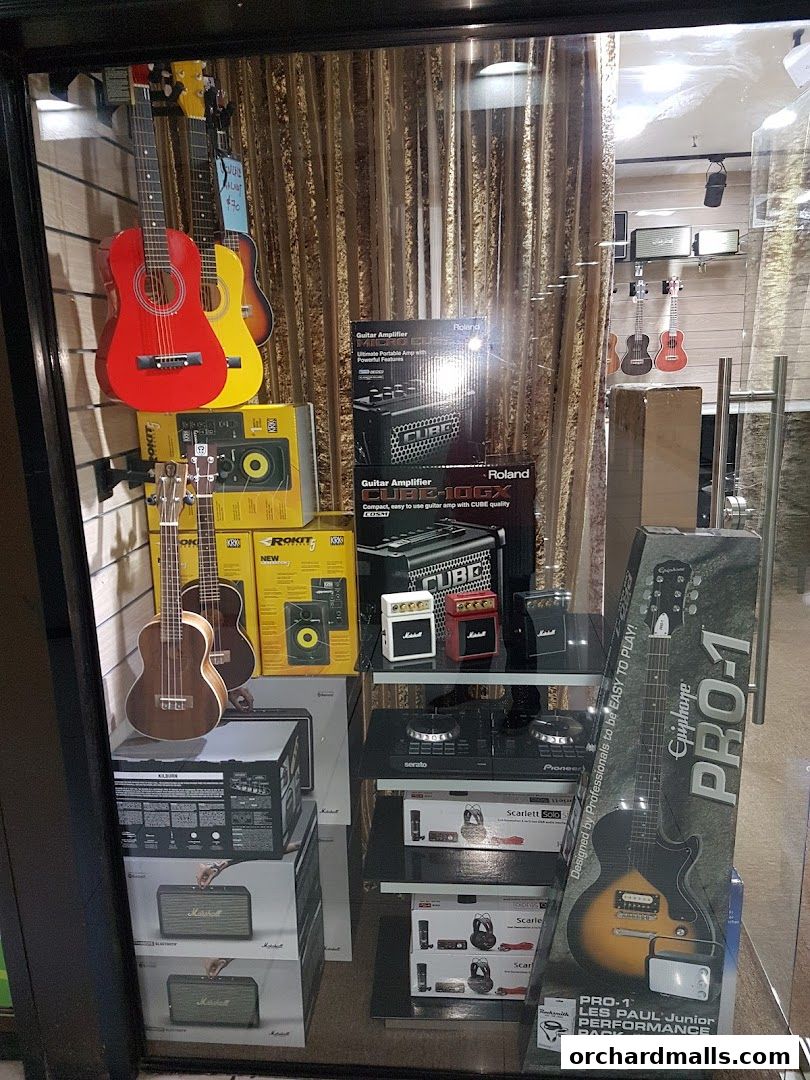 A shop window display featuring guitars, ukuleles, amplifiers, and DJ equipment.