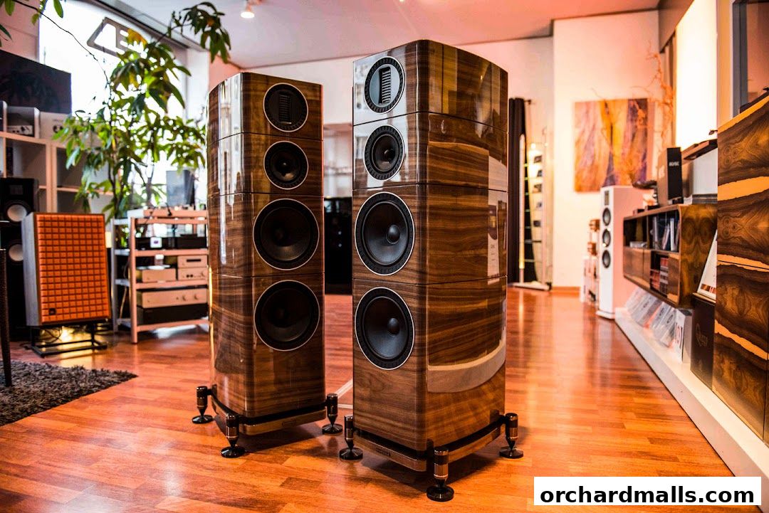 Luxurious wooden speakers displayed in a modern audio store with warm lighting.