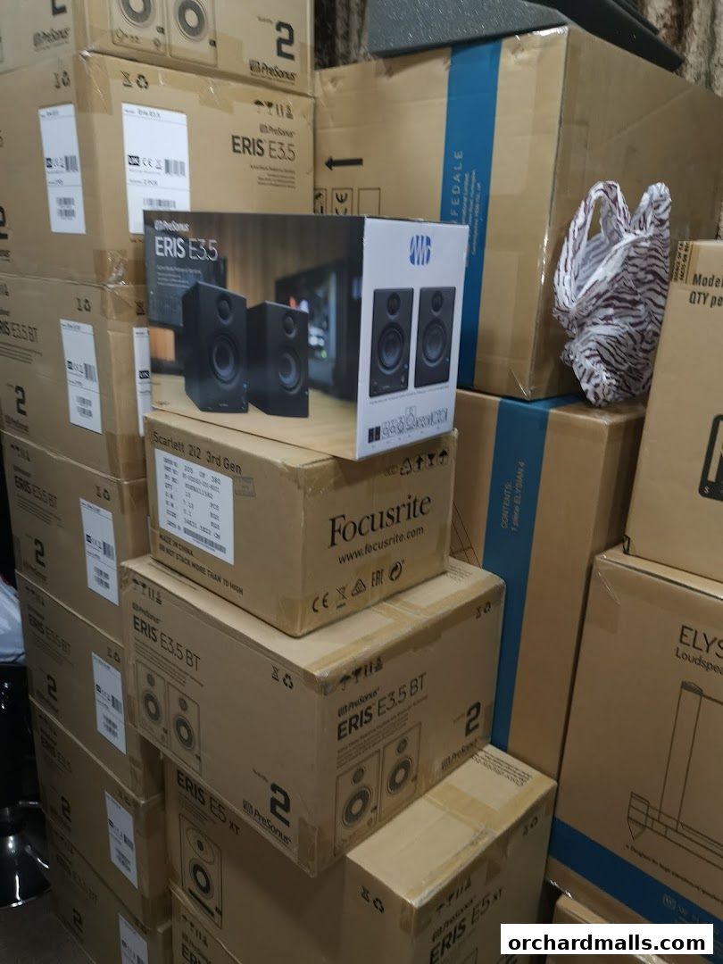 A stack of boxes containing audio equipment, including speakers and audio interfaces.