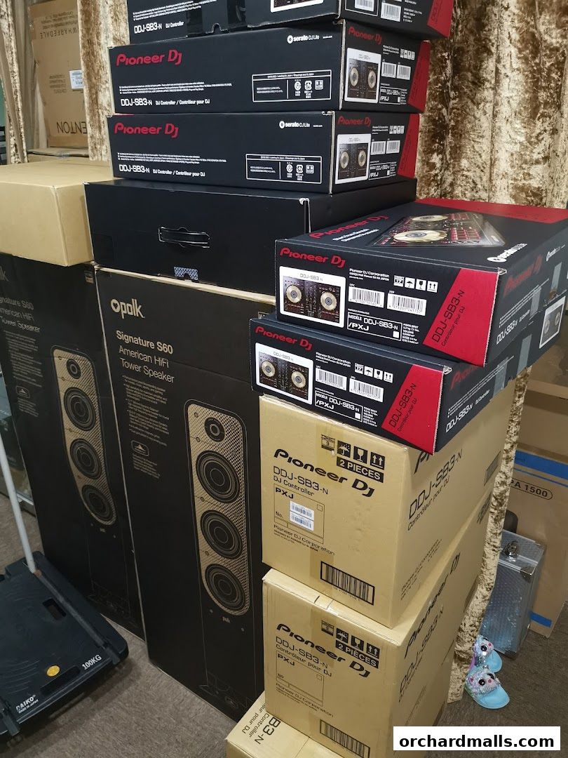 A collection of audio equipment boxes, including Pioneer DJ controllers and Polk tower speakers.
