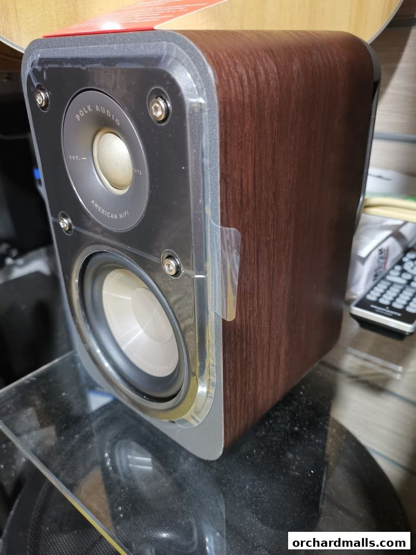 A close-up of a Polk Audio speaker with a wood-grain finish.