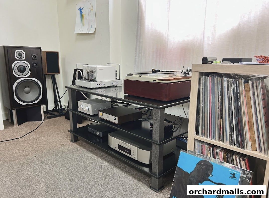 A room filled with high-fidelity audio equipment, including speakers, amplifiers, and a turntable.