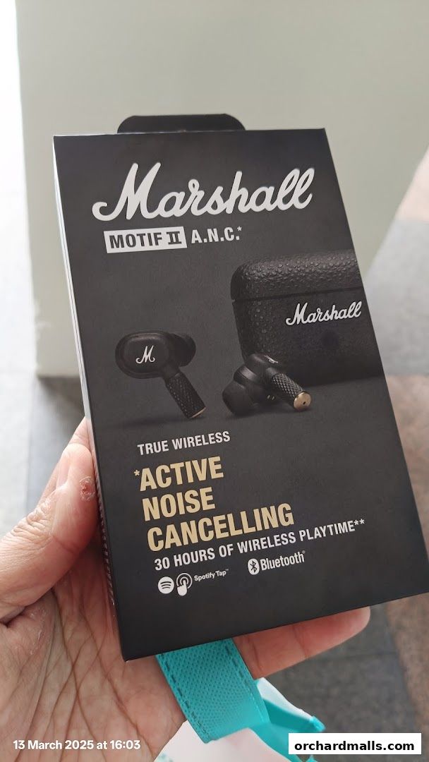 A hand holds a box of Marshall Motif II A.N.C. true wireless earbuds.