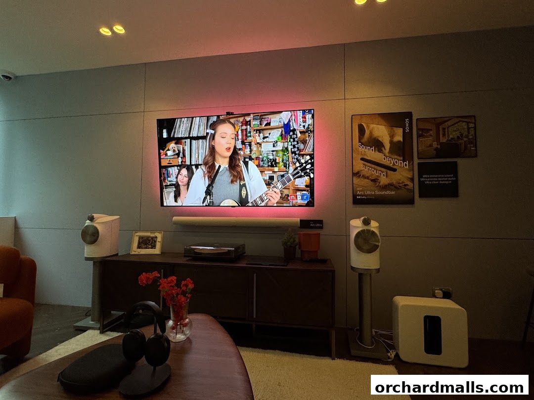A modern living room setup showcasing Sonos sound systems and a large television.