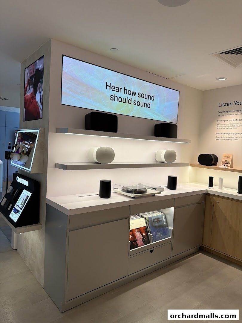 Interior of a Sonos store showcasing audio equipment and a large display screen.