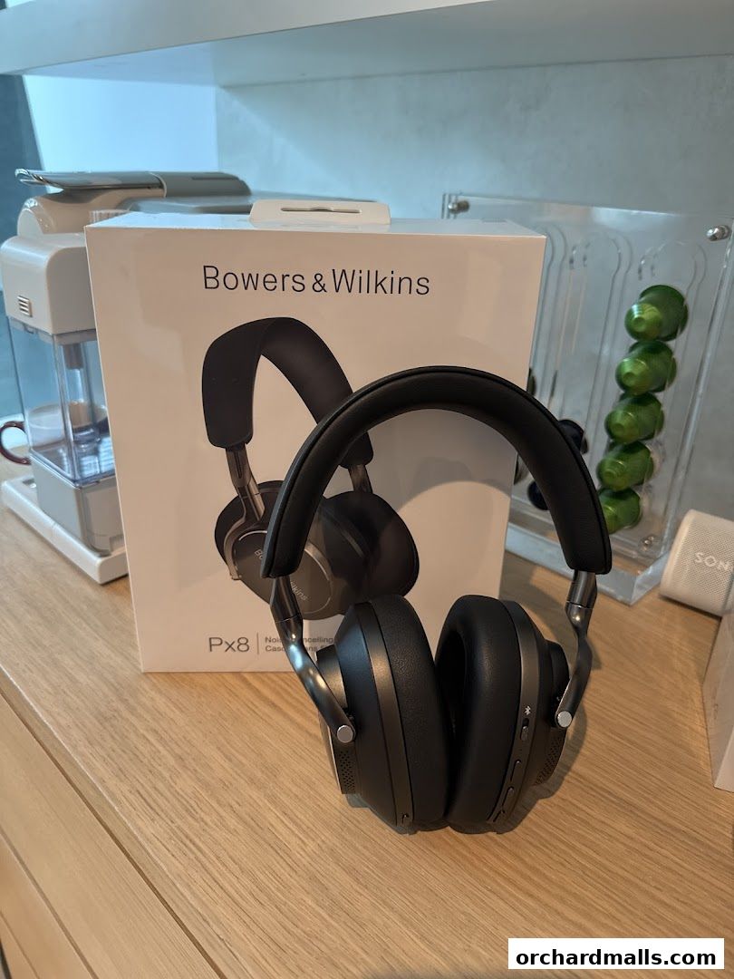 Bowers & Wilkins Px8 headphones displayed with their box on a wooden surface.