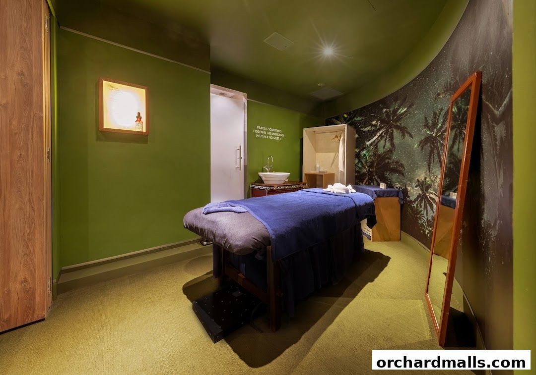 A serene spa room with massage beds, a sink, and tropical-themed wallpaper.