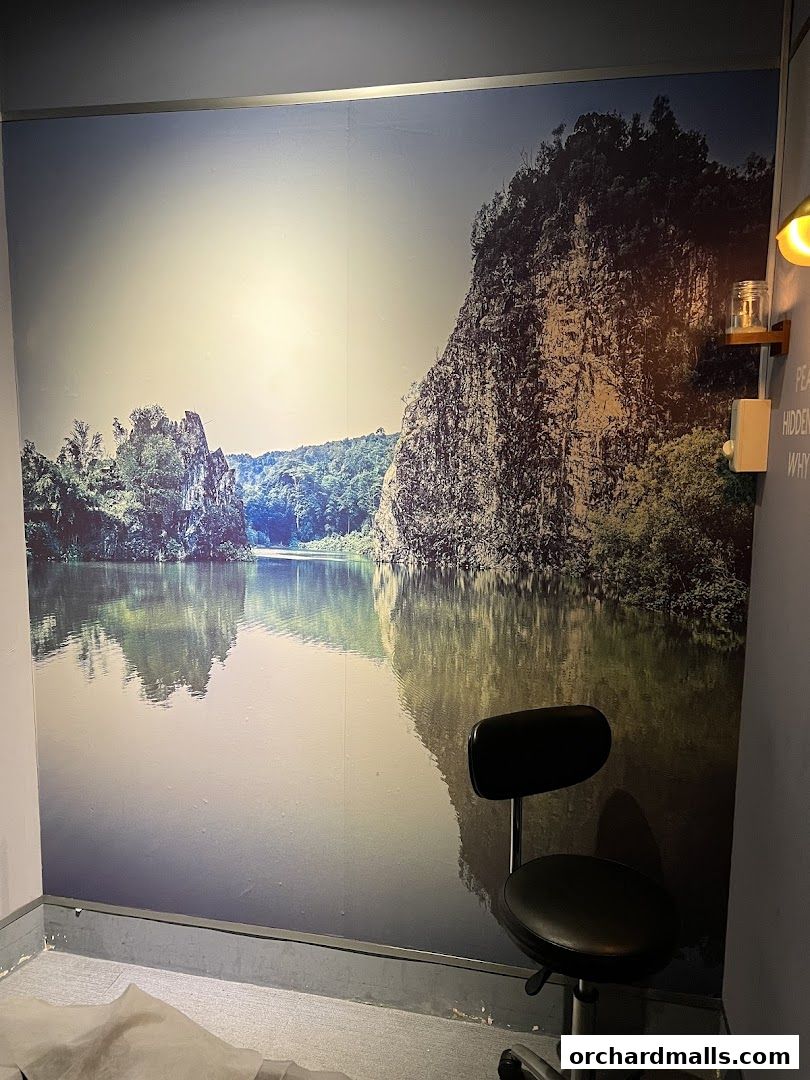 A serene mural of a lake and mountains with a chair in the foreground.