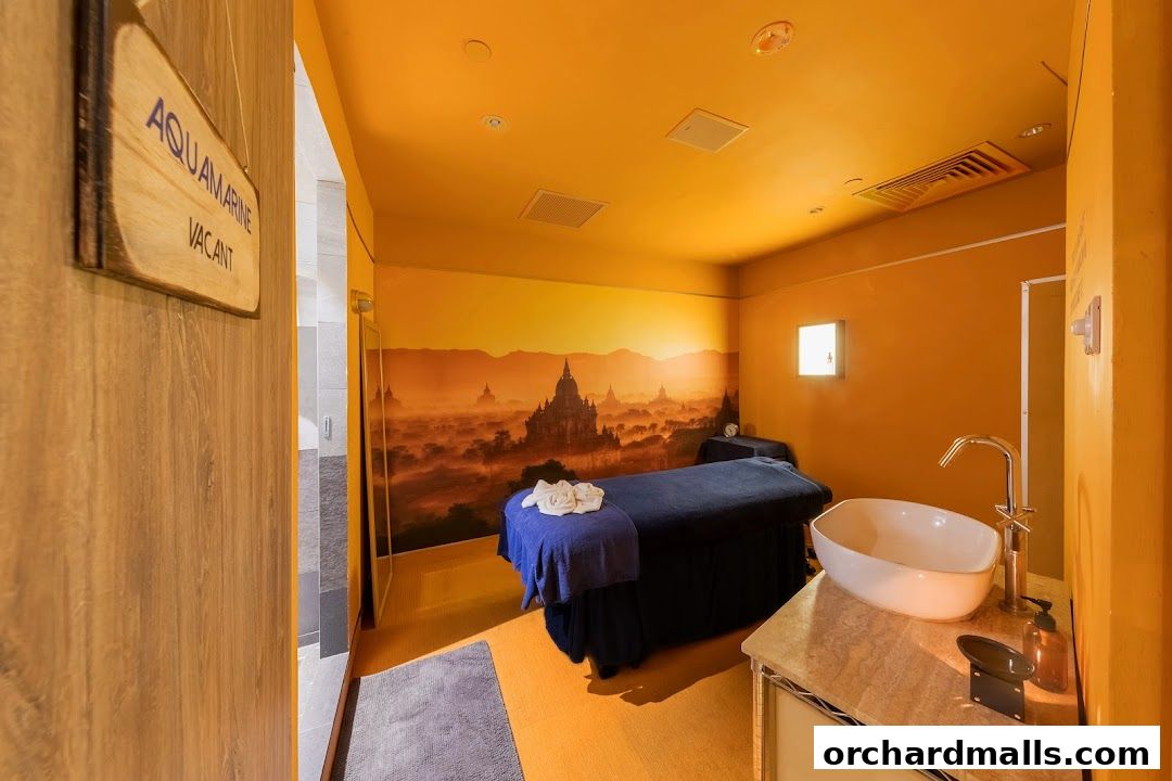 A serene spa room with massage beds, a sink, and a scenic mural.