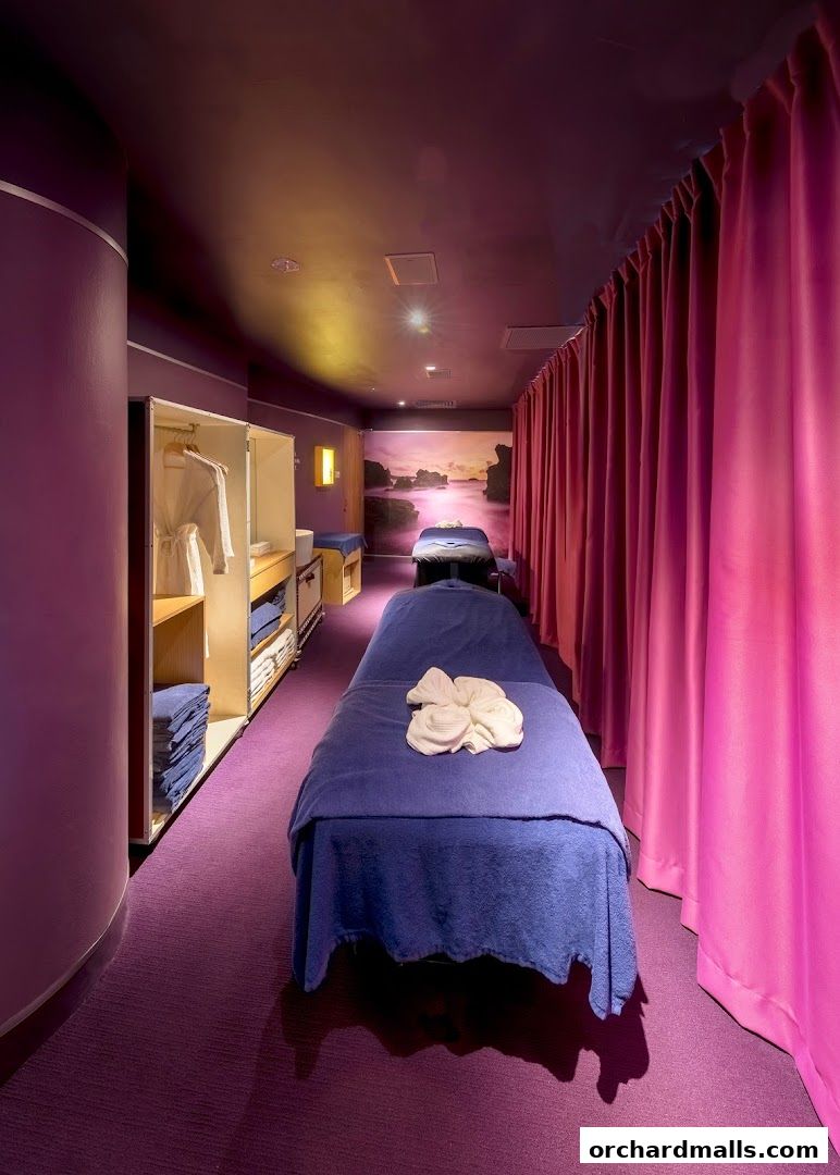 Interior view of a spa with massage beds, robes, and towels.