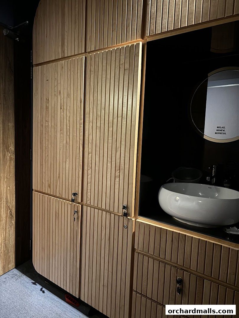 Modern spa interior with wooden cabinets, a sink, and a mirror with text.