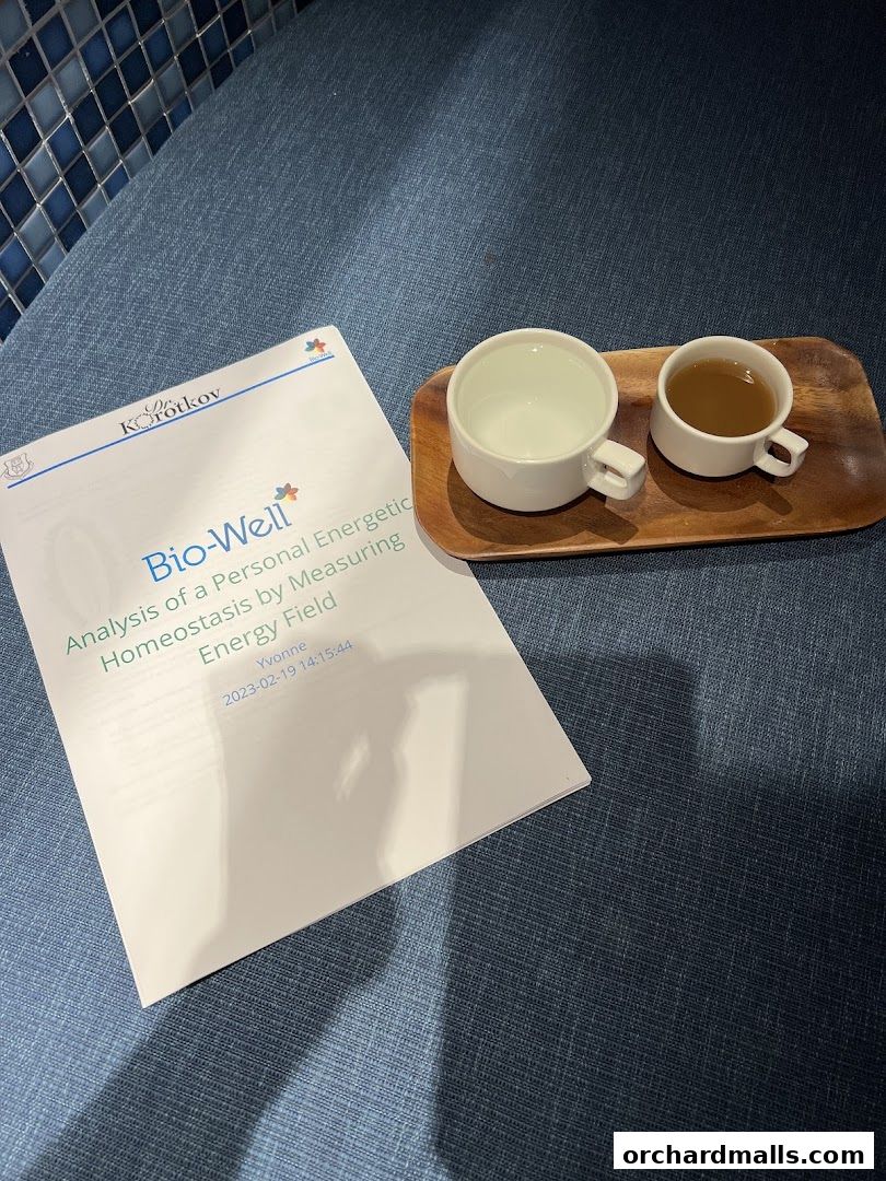 A document titled 'Bio-Well' and two cups of tea on a wooden tray.
