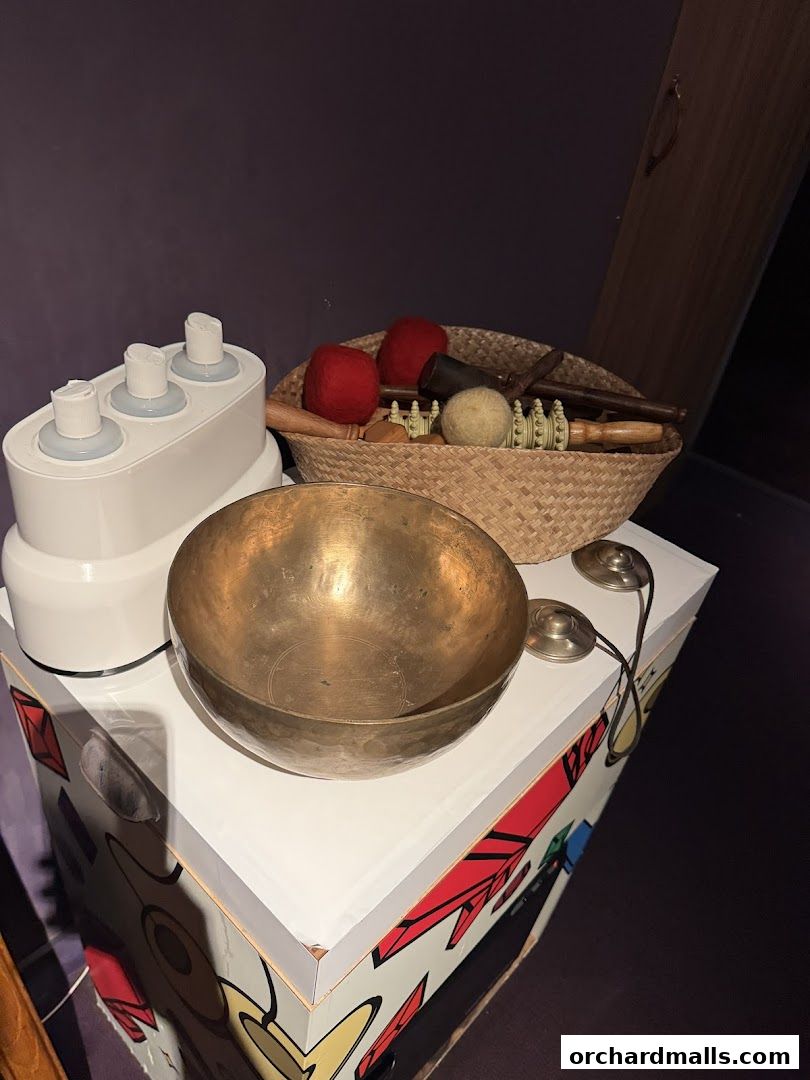 A collection of spa and wellness tools including a singing bowl, massage rollers, and felt balls.