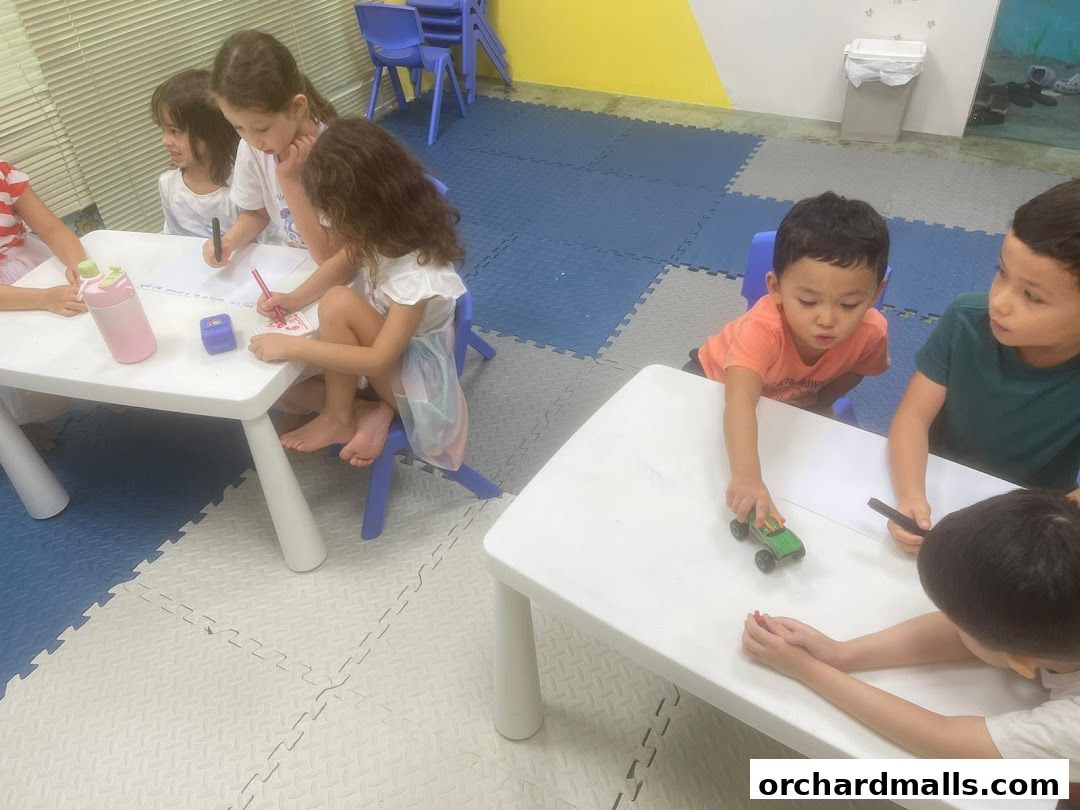 Children are engaged in a learning activity at tables in a classroom setting.