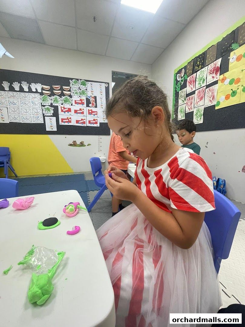 Children engaged in a creative activity with colorful modeling clay at tables.